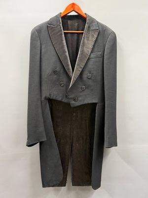 un costume gris suspendu à un cintre sur un mur blanc