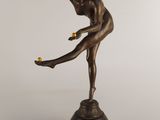 bronze statue of a woman holding a tennis racquet on a pedestal