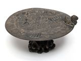 a bronze plate with a bird on it on a stand