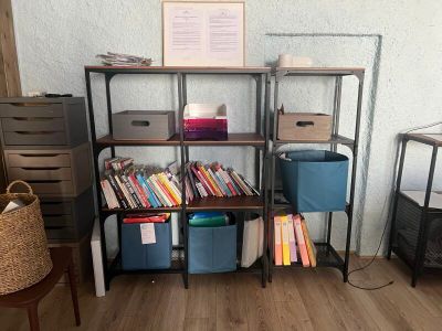 a book shelf with many books on it in a room