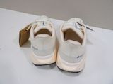 white sneakers with black laces on them sitting on a white surface