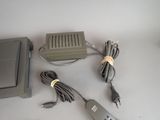 a remote control, a charger, and a cord on a table