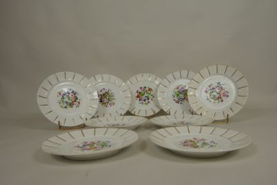 four white plates with floral designs on them sitting on a table