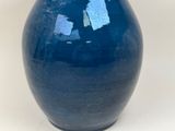 a blue vase that has a hole in it