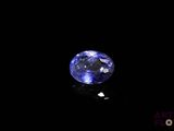 a close up of a blue sapphire stone on a black surface