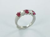 un gros plan d'une bague en or blanc sertie de trois rubis