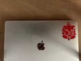 an apple laptop with a red flower sticker on it