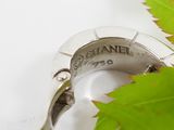a close up of a ring with a leaf in the background