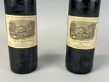two bottles of red wine sitting next to each other on a table