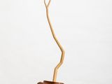 a small wooden vase with a branch sticking out of it