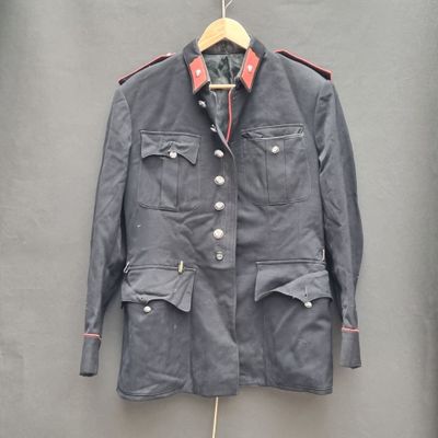 une vieille veste militaire suspendue à un cintre accroché au mur