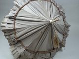 un parapluie en papier auquel est suspendu un pompon
