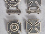 six médailles de tailles et de formes différentes sont disposées sur une surface blanche