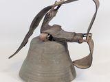 une cloche en métal surmontée d'un oiseau