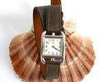 a watch sitting on top of a shell with a shell in the background