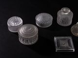 five glass jars and a small box on a black surface
