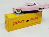 a pink toy car sitting on top of a yellow box