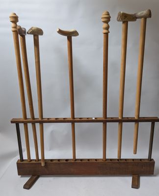 a rack with four wooden baseball bats and a bat holder