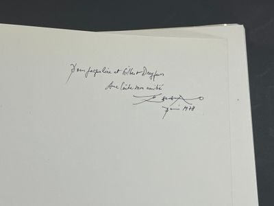 un livre ouvert, sur lequel est inscrit un poème écrit à la main, posé sur une table