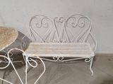 a white bench and a table with a basket on top of it