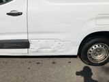 a white van that has been damaged and is parked on the side of the road