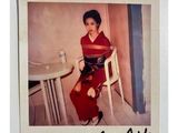 une photo Polaroid d'une femme assise sur une chaise