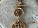 a close up of a gold medal with a cross on it
