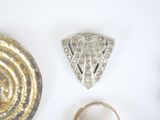 three rings and a brooch on a white surface