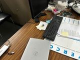un bureau sur lequel se trouvent un ordinateur portable, un clavier, une souris et des papiers