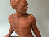 statue of a man holding a surfboard in his right hand