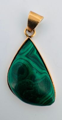 un gros plan d'un pendentif vert sur une surface blanche