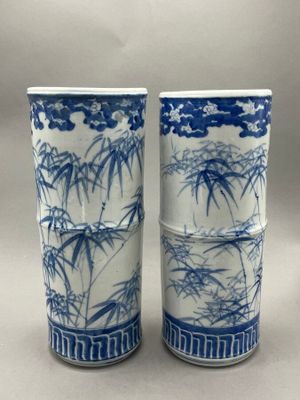 pair of blue and white vases with bamboo trees on them