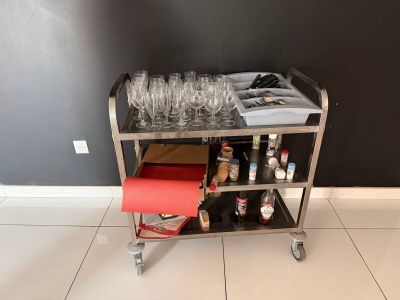 un chariot à apéritif sur lequel sont disposés de nombreux verres à vin