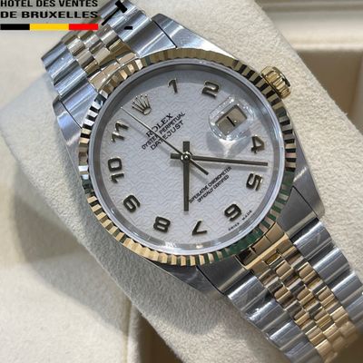 Montre Rolex avec cadran blanc et bracelet bicolore, exposée en vitrine
