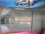a close up of a bosch drill with a pink piece of paper next to it