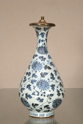 un vase bleu et blanc posé sur une table en verre