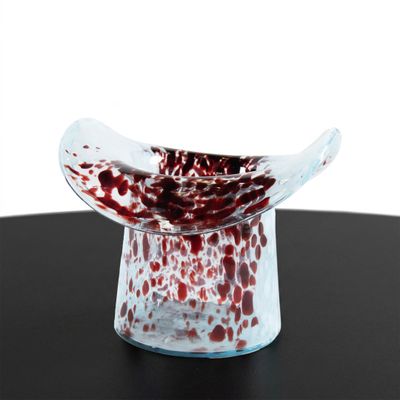 a red and white bowl sitting on a black table