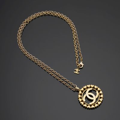 un collier en or avec un pendentif circulaire et une chaîne