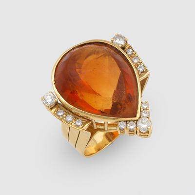 an image of a ring with an orange stone surrounded by diamonds