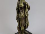 bronze statue of a woman holding a book on a marble base