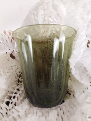 un verre vert posé sur un napperon napperon