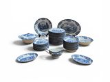 a pile of blue and white plates on a white surface