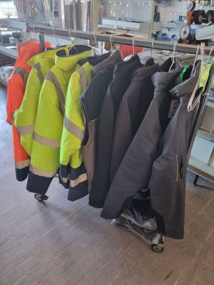 de nombreuses vestes suspendues à un portant dans une pièce