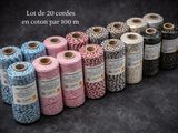 several spools of twine of different colors and sizes on a black background
