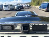 a police car parked in a parking lot with other cars in the background