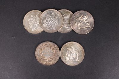 six types de pièces différents sont représentés sur une surface noire