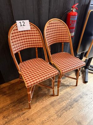 two wicker chairs with a price tag on the back of them
