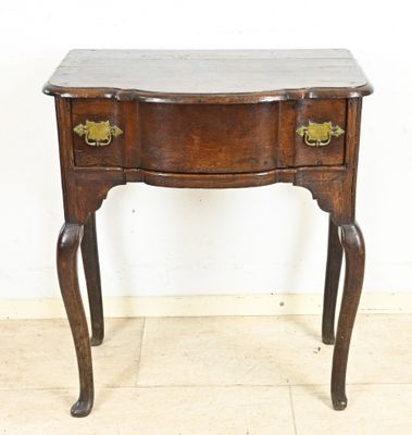 a small wooden table with two drawers on it