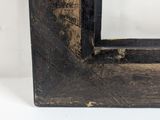 an old wooden picture frame with a black stain and a white background