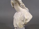 white marble bust of a woman with braids on her hair
